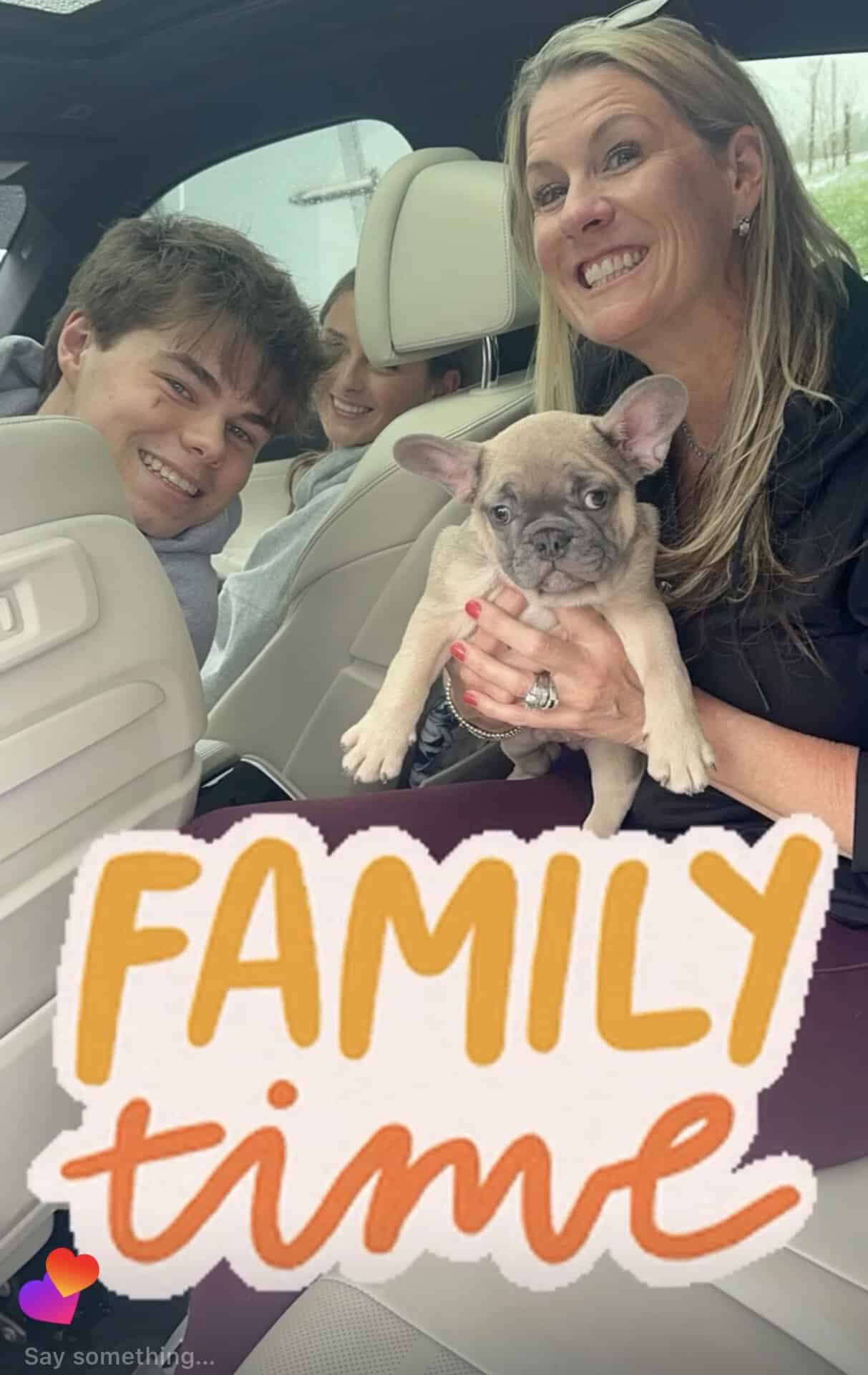 Mom and two teens in the car with their new lilac Frenchie puppy