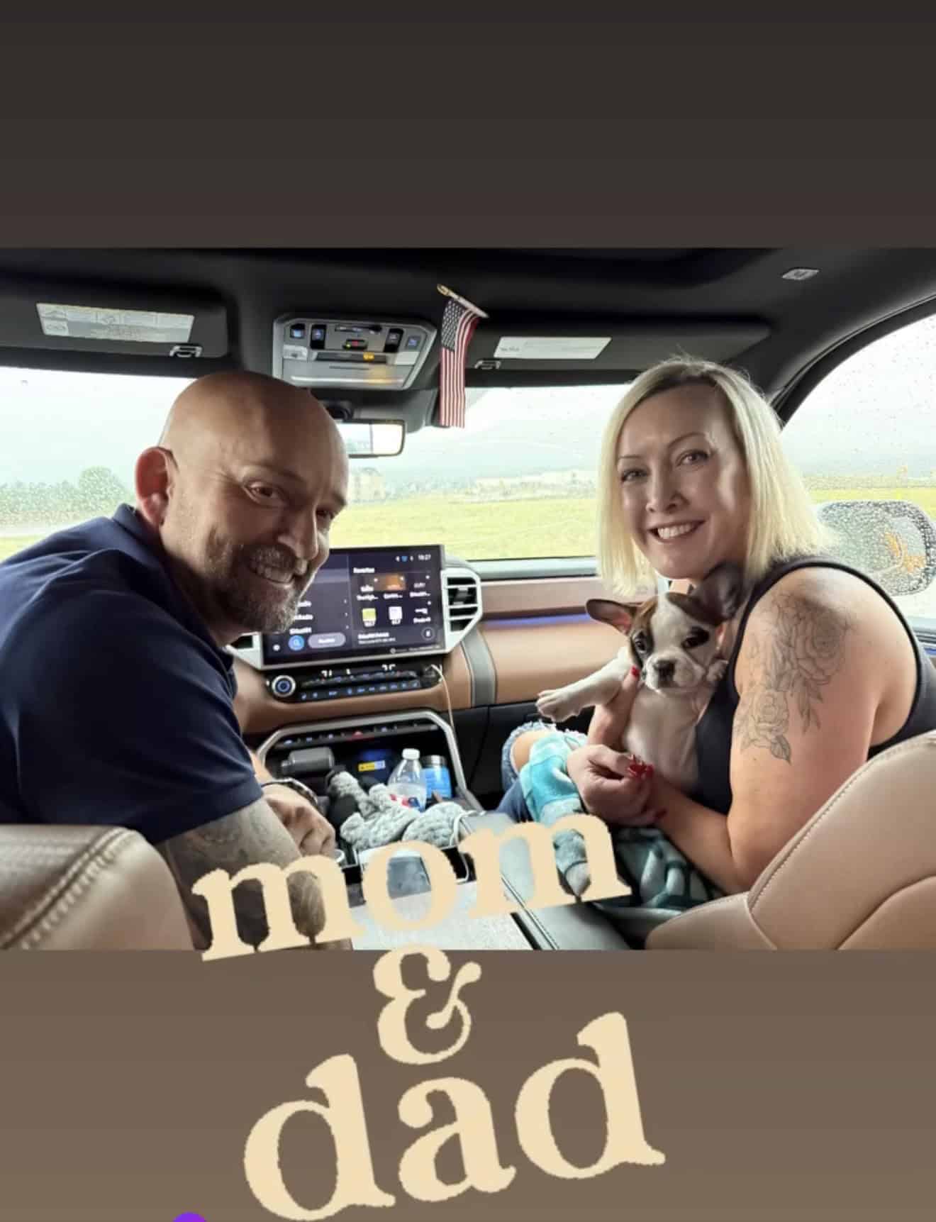 Couple in their truck holding their new Frenchie puppy for the ride home